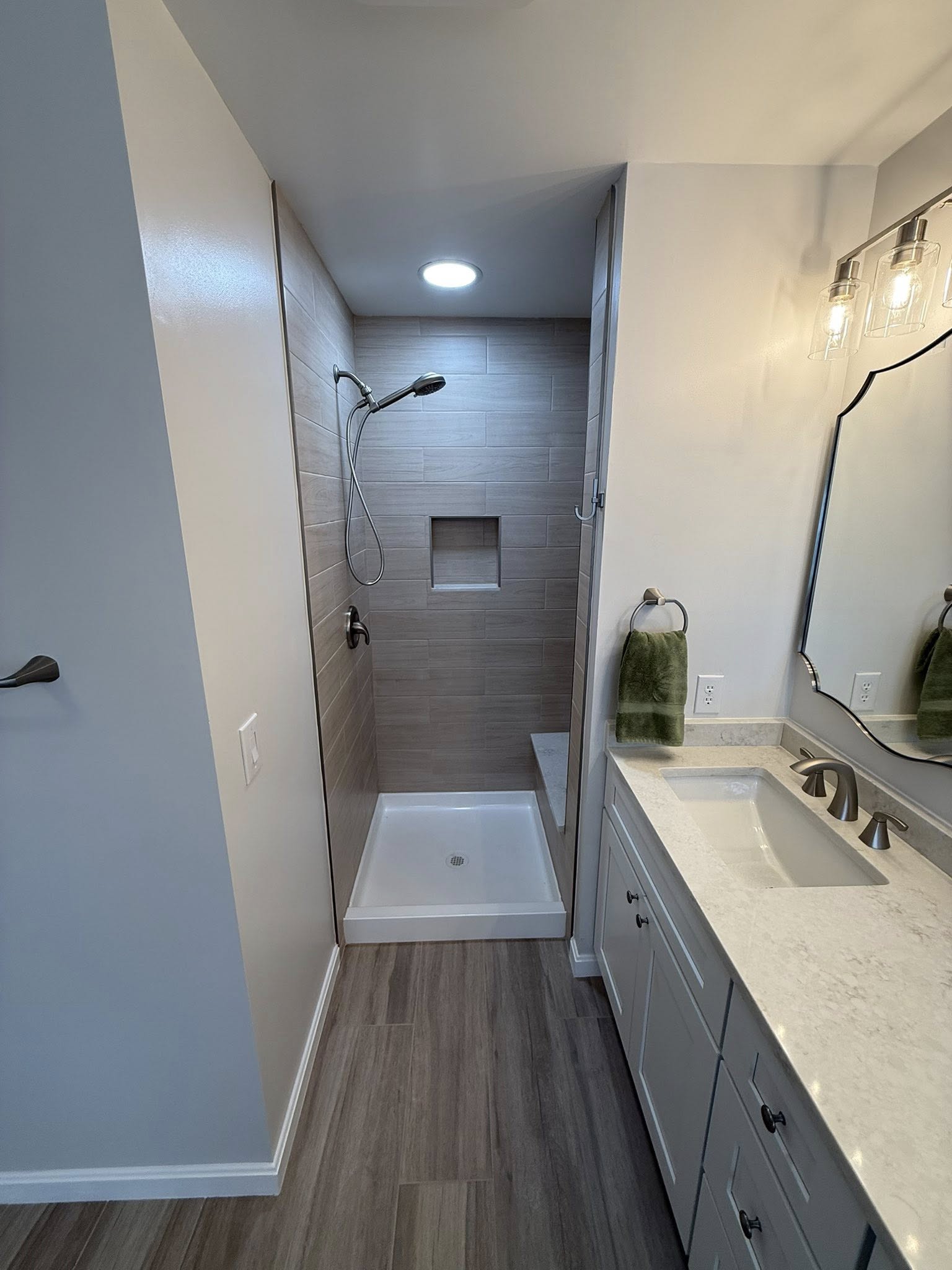 Bathroom overhaul featuring new flooring, vanity, and improved lighting